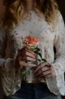 Обрізаний вид жінки, що тримає троянду в руках — стокове фото