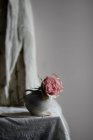 Pink rose blossom in vintage ceramic vase on table — Stock Photo