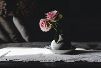 Розовые цветы розы в винтажной керамической вазе в солнечном свете — стоковое фото