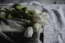 Bouquet de tulipes blanches sur livre vintage, gros plan — Photo de stock