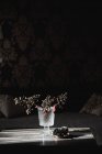 Сушеные ветви с лесными ягодами в стеклянной вазе в интерьере дома — стоковое фото