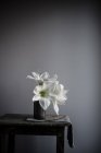 Flores de lírio branco em vaso na mesa — Fotografia de Stock
