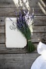 Lavender flowers tied in bunch on papers — Stock Photo