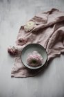 Buttercup blossom in ceramic bowl on pastel cloth — Stock Photo