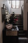 Home interior with lily flowers decoration on bureau by stairs — Stock Photo