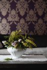 Цветочные композиции с розами и растениями мимозы в керамическом горшке — стоковое фото