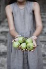 Abgeschnittene Ansicht eines Teenie-Mädchens mit grünen Birnen — Stockfoto