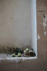 Green pears on pile of ancient papers in shabby wall niche — Stock Photo