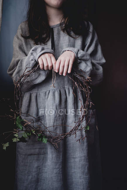 Cropped view of teen girl holding twig wreath — Stock Photo