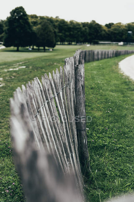 Rural scene of wooden palisade fence in green garden — Stock Photo