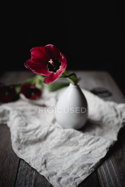 Tulipán rojo en jarrón sobre mesa rústica — Stock Photo