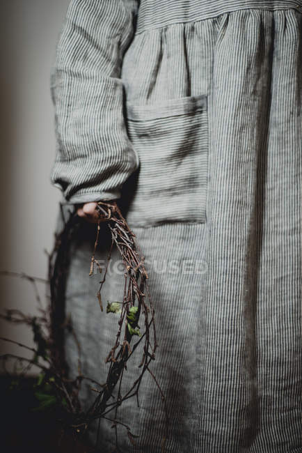 Cropped view of girl holding twig wreath in hand — Stock Photo