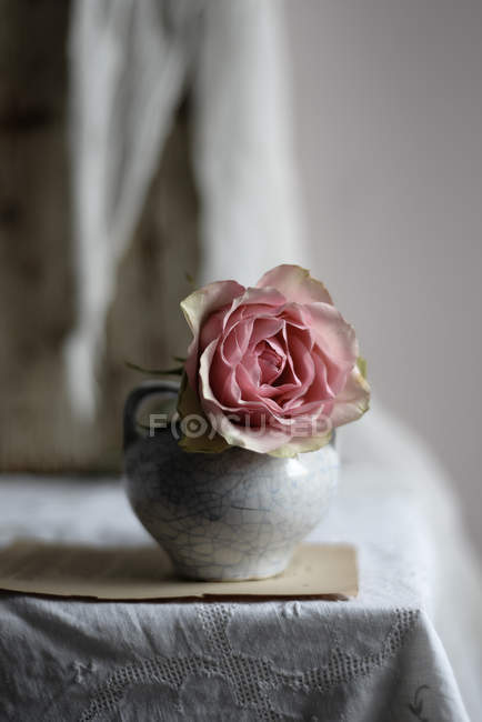 Rosa rosa em vaso de cerâmica vintage na mesa, close-up — Fotografia de Stock