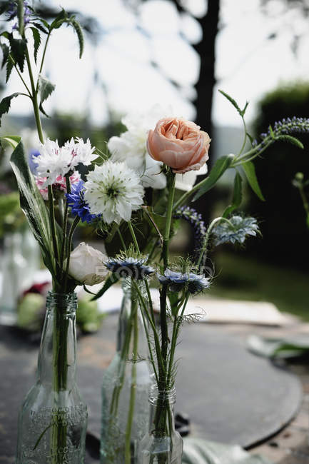 Arranjo floral de várias flores de verão em garrafas — Fotografia de Stock