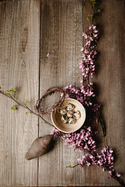 Пасхальное украшение с перепелиными яйцами в глиняной чаше и цветении деревьев — стоковое фото