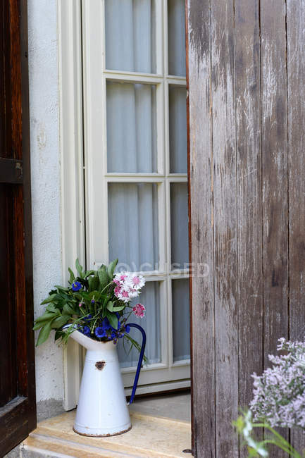 Blumenschmuck mit bunten Kornblumen in Metallkanne auf der Veranda — Stockfoto