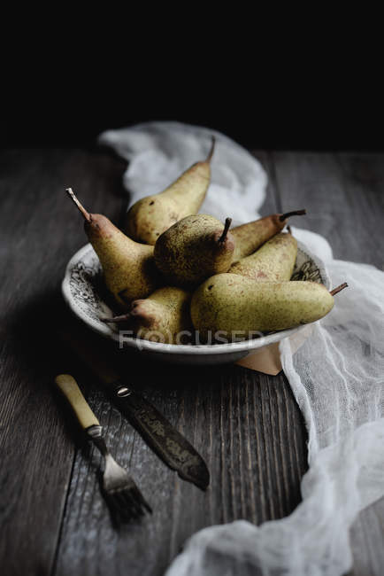 Still life with pears in vintage porcelain bowl on rustic table — Stock Photo