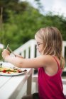 Girl eating lunch on porch, selective focus — Stock Photo