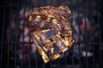 Vista superior de carne grelhada na grelha de churrasco — Fotografia de Stock