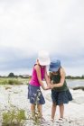 Дві дівчини грають на пляжі, зосередьтеся на передньому плані — стокове фото