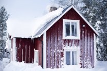 Maison en bois rouge recouverte de givre — Photo de stock