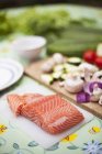 Нарізаний лосось з овочевими інгредієнтами на столі — стокове фото