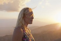 Женщина турист отдыхает в горном пейзаже на закате — стоковое фото