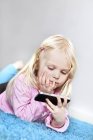 Blonde girl using cell phone, selective focus — Stock Photo