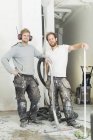 Dos hombres en casa de renovación de ropa de trabajo de protección, enfoque selectivo - foto de stock