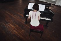 Задний вид женщины, играющей на пианино — стоковое фото