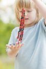 Portrait of girl holding straw with wild strawberries and blueberries — Stock Photo
