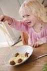 Девушка ест спагетти с фрикадельками, избирательный фокус — стоковое фото