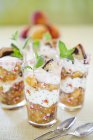 Peach compote trifle with cream and mint leaves — Stock Photo
