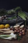 Variación de verduras frescas recogidas y limones en la mesa - foto de stock