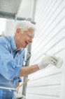 Sorridente homem sênior parede de pintura — Fotografia de Stock