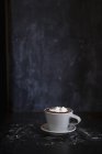 Чашка горячего шоколада со сливками на столе — стоковое фото