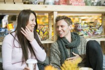 Man and woman laughing in shop, differential focus — Stock Photo