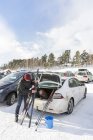 Mann präpariert Ski aus weißem Auto — Stockfoto