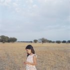 Фронтальний вид дівчина в Білій сукні на родовищі — стокове фото