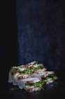 Sanduíches embrulhados com legumes em verdes no fundo escuro — Fotografia de Stock