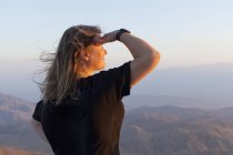 Female tourist looking at view at sunset — Stock Photo