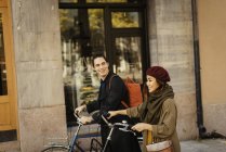 Duas pessoas andando com bicicletas, foco seletivo — Fotografia de Stock