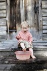 Мальчик моет ноги на деревянных ступеньках — стоковое фото