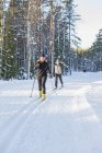 Couple skiing in forest, focus on foreground — Stock Photo