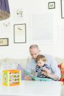 Мужчина читает сыну в гостиной — стоковое фото