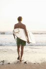 Мбаппе с доской для серфинга, идущей к морю в Коста-Рике — стоковое фото