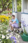 Woman sitting at front stoop of garden house — Stock Photo