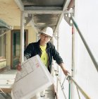 Portrait of construction worker with blueprints looking away — Stock Photo