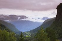 Vista de montañas, valle verde y nubes bajas en Más og Romsdal, Noruega - foto de stock