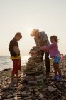 Nonno e nipoti, facendo cumuli di pietra — Foto stock